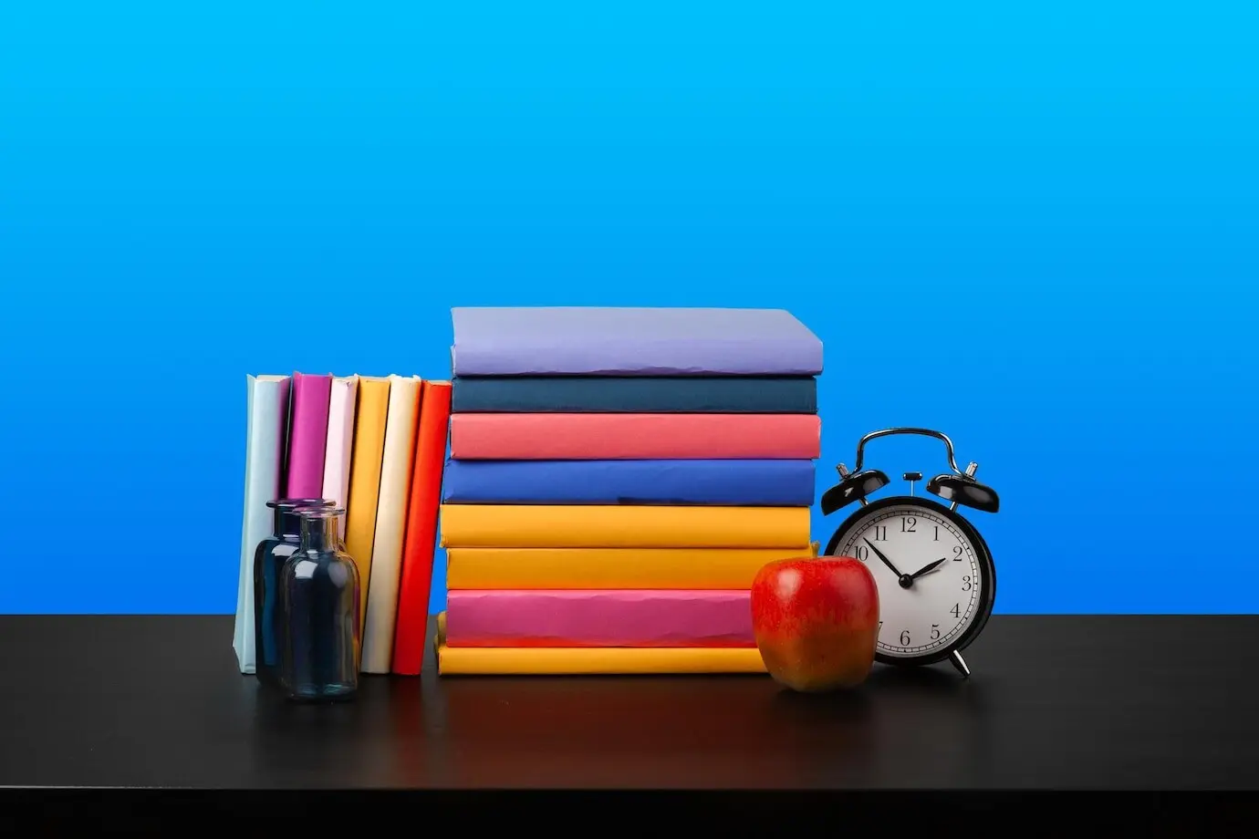 Ein Bücherstapel auf einem schwarzen Holztisch